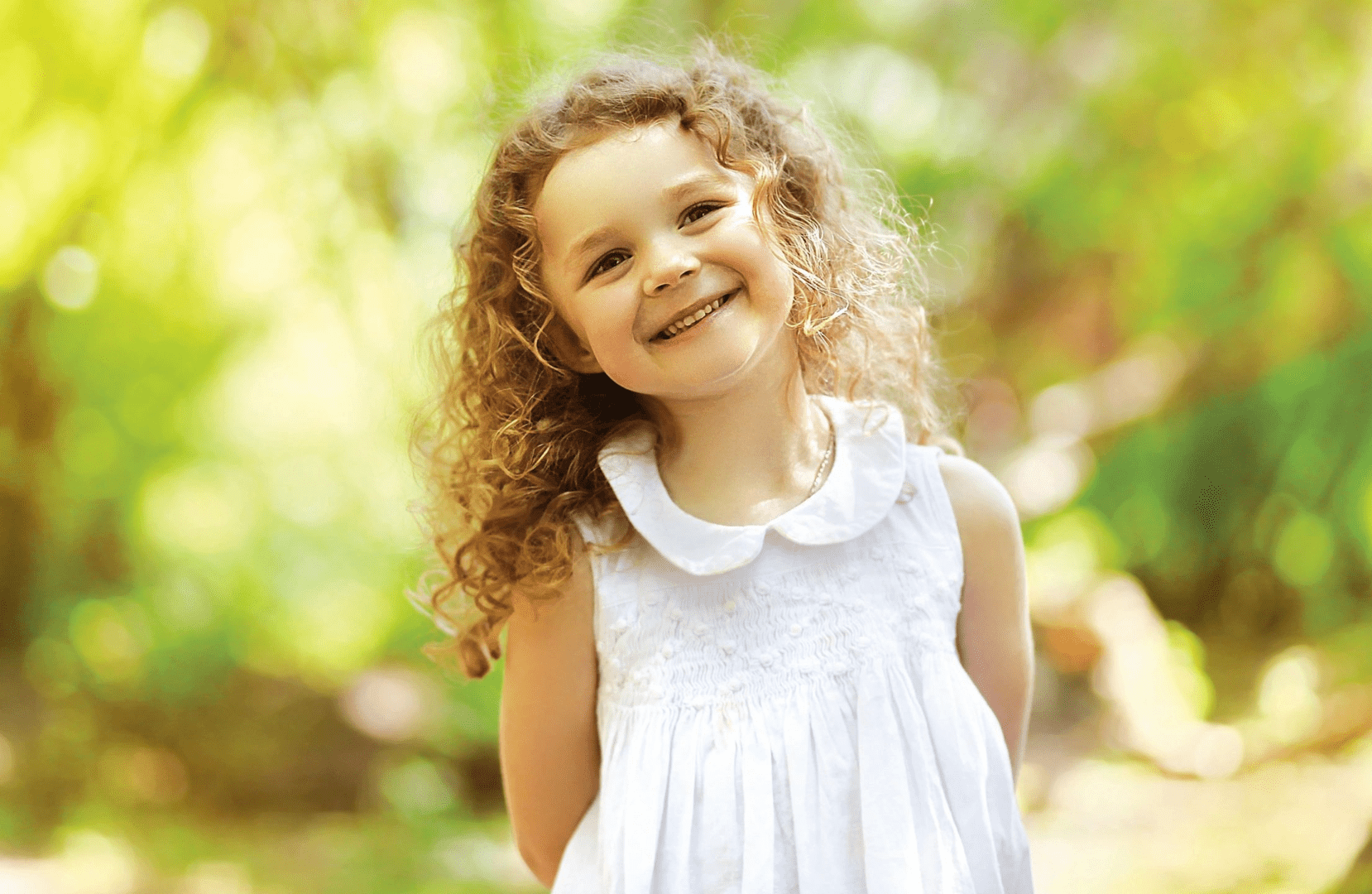 A little girl outdoors smiling
